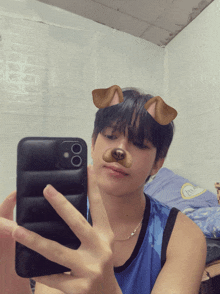 a young man taking a picture of himself with a dog face mask on his face