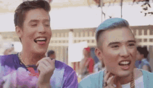 two young men are eating cotton candy at a carnival .