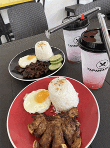 a table with plates of food and two cups that say tapawar