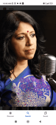 a woman singing into a microphone on a cell phone
