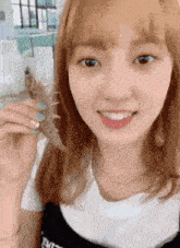a young woman is holding a piece of paper in her hand .