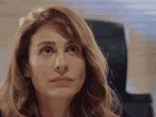 a woman with long hair is sitting in a chair and looking up at the camera .