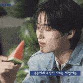 a man in a denim jacket is eating a slice of watermelon with the word offee in the corner