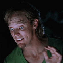 a man in a green shirt making a funny face