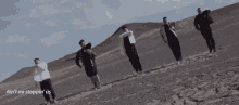 a group of men standing on top of a sandy hill with the words ain t no stoppin us above them