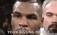 a close up of a boxer 's face with the words `` your pissing me off '' .