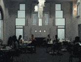 a group of women sit at tables in a dark room