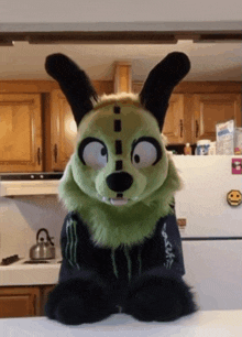 a stuffed animal with a monster energy shirt on is sitting on a counter