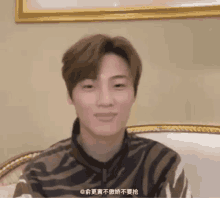 a man in a zebra print shirt is sitting on a chair and smiling