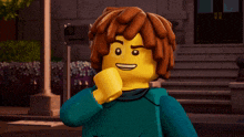 a lego character with brown hair and a blue shirt is standing in front of a building