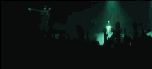 a man is playing a guitar in front of a crowd