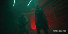 a man and a woman are dancing in a dark room with the website gifrun.com visible in the corner .