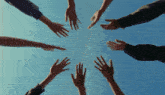 a group of people reaching up towards the sky with their hands