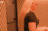 a woman with long blonde hair is standing in front of a wall with a pattern and the word tv written on it