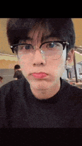 the boy is wearing glasses and making a funny face .
