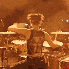 a woman is playing a drum set on a stage .