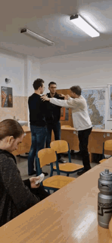 a group of people are standing in a room with a map on the wall that says england