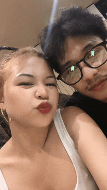 a man and a woman are posing for a picture and the woman is wearing red lipstick