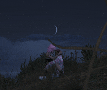 a man and a woman kissing under a crescent moon