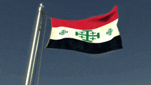 a flag with a cross on it is flying in the wind