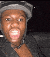 a man wearing a helmet is making a funny face with his mouth open