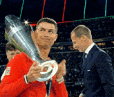 a man holding a trophy that says uefa champions league