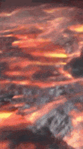a painting of a sunset over a body of water with a blurred background .