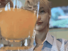 a man is holding a glass of orange juice with the words cheers written on the bottom
