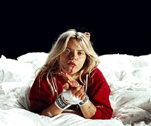 a woman laying on a bed wearing boxing gloves and a red shirt with the word fox on it