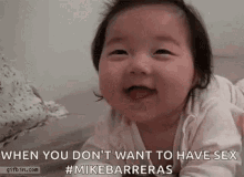 a baby is laying on its stomach on a bed and smiling at the camera .