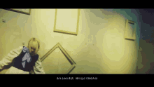 a woman with blonde hair is standing in front of a wall with frames on it in a dark room