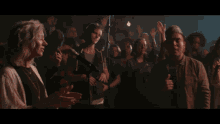 a man singing into a microphone in front of a crowd of people
