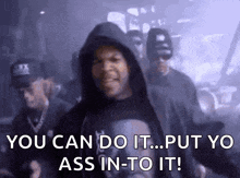 a man in a hooded shirt is standing in front of a group of men .