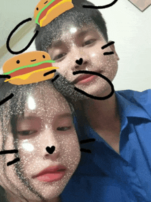a boy and a girl are posing for a picture with hamburgers on their faces