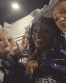 a group of cheerleaders are posing for a picture and one of them is wearing a shirt with the letters h65 on it