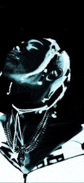 a black and white photo of a man with dreadlocks and a necklace