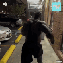 a man is running down a sidewalk in front of a building with a sign that says positive on it