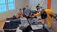 a group of people are playing a game in a living room and one of them is wearing a yellow raincoat