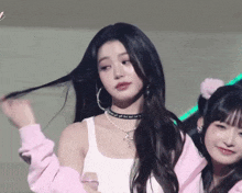 a woman wearing a choker and hoop earrings is standing next to another girl