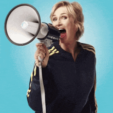 a woman is holding a megaphone with her mouth wide open