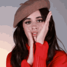 a woman wearing a beret and a red shirt is making a funny face .