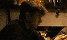 a man in a black sweater is sitting at a table
