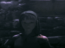 a girl with a scarf around her head is looking at the camera
