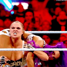 a woman with purple hair is wrestling another woman in a ring with the words ethenextbigthing on the bottom right