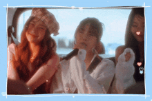 three girls are sitting in the back seat of a car and one of them is singing into a microphone