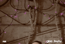 a woman is laying on a bed with purple lights behind her and the words glee hulu are on the bottom