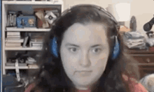 a woman wearing headphones is making a funny face while sitting in front of a microphone .