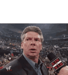 a man in a suit and tie is talking into a microphone .