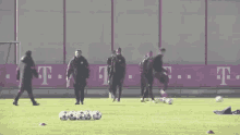 a group of soccer players are practicing on a field in front of a t-mobile banner