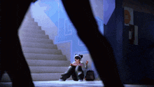 a girl sits on a set of stairs in front of a wall with the letter l painted on it